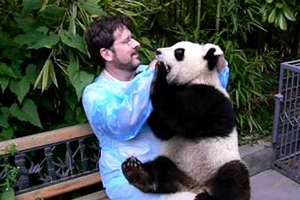 Un uomo che tiene in braccio un panda